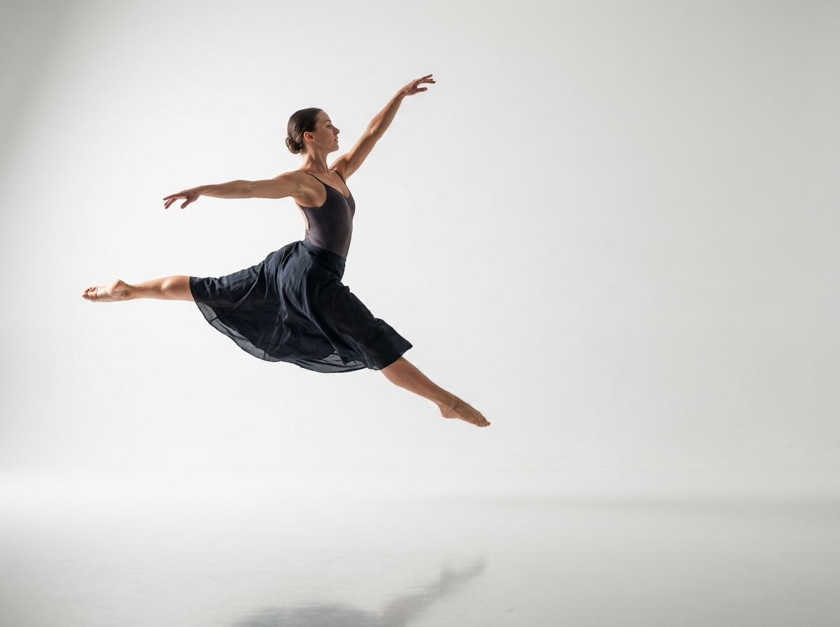 Contemporary dancer captured mid-leap in a studio